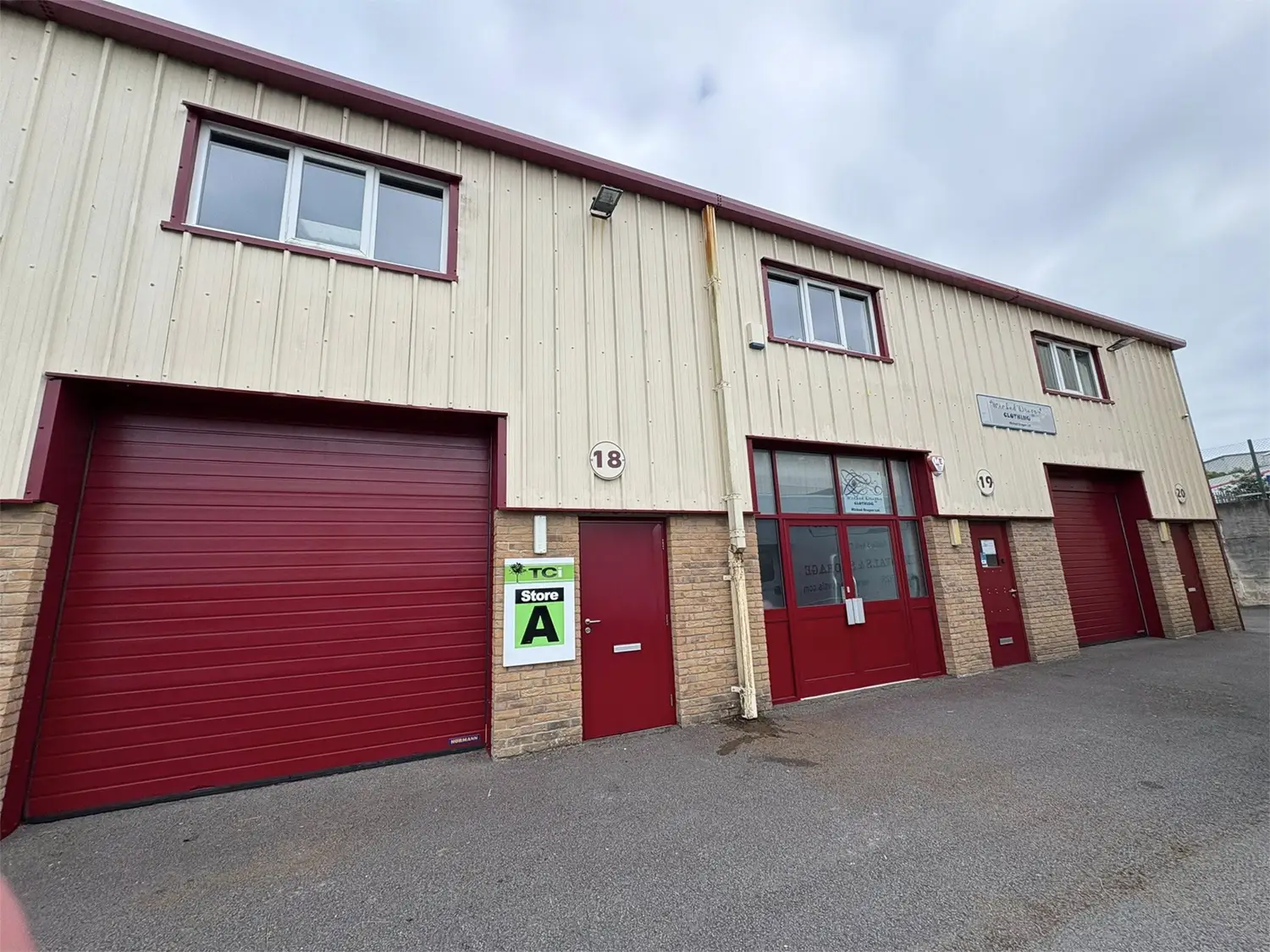 Finished industrial unit exterior with coordinated cladding, frames and roller shutter doors